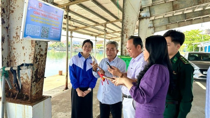 Des pêcheurs scannent le code QR au port de Tiên Châu. Photo : nhandan.vn