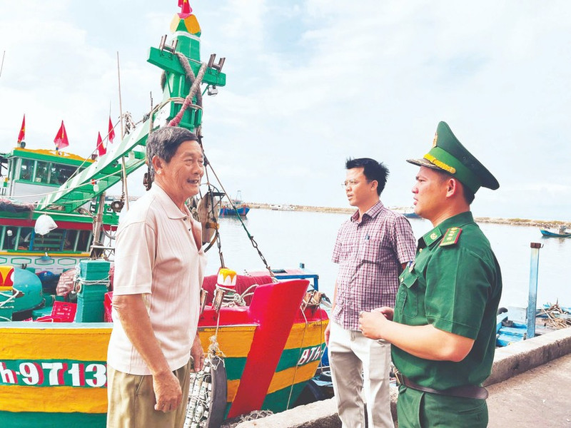 Un cadre du poste frontière de Thanh Hai (province de Lam Dong) et un représentant du comité populaire du quartier de Phu Thuy sensibilisent les pêcheurs à la préparation des élections. Photo : NDEL.