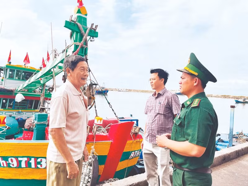 Un cadre du poste frontière de Thanh Hai (province de Lam Dong) et un représentant du comité populaire du quartier de Phu Thuy sensibilisent les pêcheurs à la préparation des élections. Photo : NDEL.