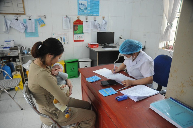 Le personnel médical examine et vérifie l'état de santé de l'enfant avant la vaccination. Photo : VNA.