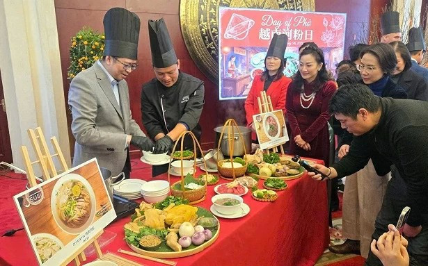 Des invités ont l'occasion de découvrir comment est préparé un bol de Phở. Photo : baoquocte.vn