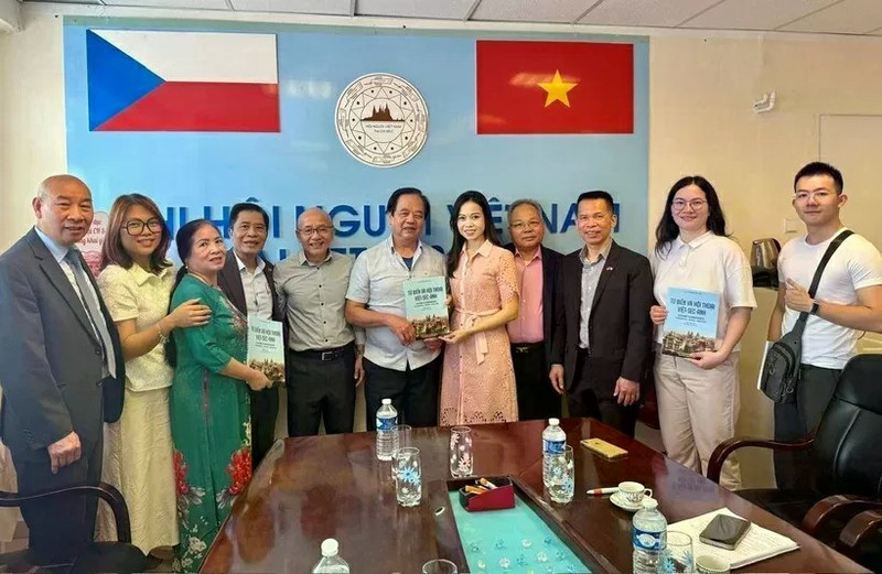 Le traducteur Nguyen Quyet Tien (6e de la gauche) offre au Centre de langue vietnamienne la collection de dictionnaires et de conversations vietnamien-tchèque-anglais qu’il a lui-même rédigée. Photo : VNA.