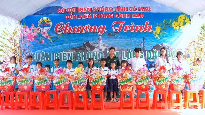 Le colonel Pham Minh Giang, commissaire politique des gardes-frontières de Ca Mau (au centre), remet des cadeaux à des élèves défavorisés des zones côtières de Ganh Hao. Photo : NDEL.