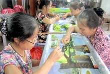 Les brodeuses du village de Minh Lang réalisent avec minutie une fresque paysagère. Photo : VOV2.