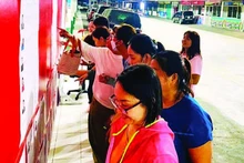 Des ouvriers de l’entreprise Pouyuen Vietnam Co., Ltd. consultent les biographies des candidats affichées dans l’enceinte de l’usine.