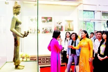 Des visiteurs admirent l’originale de la statue du Bodhisattva Tara, classée trésor national, dans l’espace d’exposition « Trésors nationaux – Un patrimoine au cœur de Da Nang ».