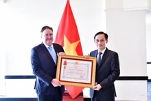 Le ministre des Affaires étrangères, Le Hoai Trung (droite), remet l’Ordre de l’Amitié à l’ambassadeur américain Marc Knapper. Photo : VNA. 