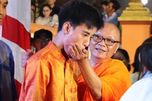 Rite du nourrissage au riz plat (cốm dẹp, sorte de jeune riz gluant aplati) lors de la fête de la Lune. Photo : VNA 