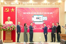 Les délégués appuient sur le bouton pour lancer la version en ligne en langue coréenne du journal Nhan Dan. Photo : TIEN DAT 