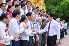 Le président Luong Cuong (à droite) serre la main des journalistes chevronnés, à Hanoi, le 20 juin.
