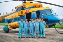 L’équipage de l’hélicoptère Mi‑171, immatriculé SAR‑03, pose pour une photo souvenir après avoir accompli avec succès une mission de transport d’aide humanitaire à destination des populations sinistrées des inondations à Nghệ An et dans les provinces montagneuses du nord du Vietnam. Photo : Thai Hieu