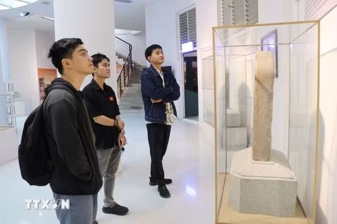 Des visiteurs découvrent et admirent des artefacts de la culture Cham exposés au Musée provincial de Khanh Hoa. Photo : VNA