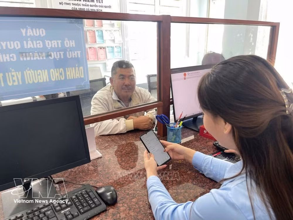 Le Centre de services administratifs publics de la commune de Nha Bich guide les résidents sur la manière d'effectuer des démarches administratives à l'aide de leurs smartphones. Photo : VNA