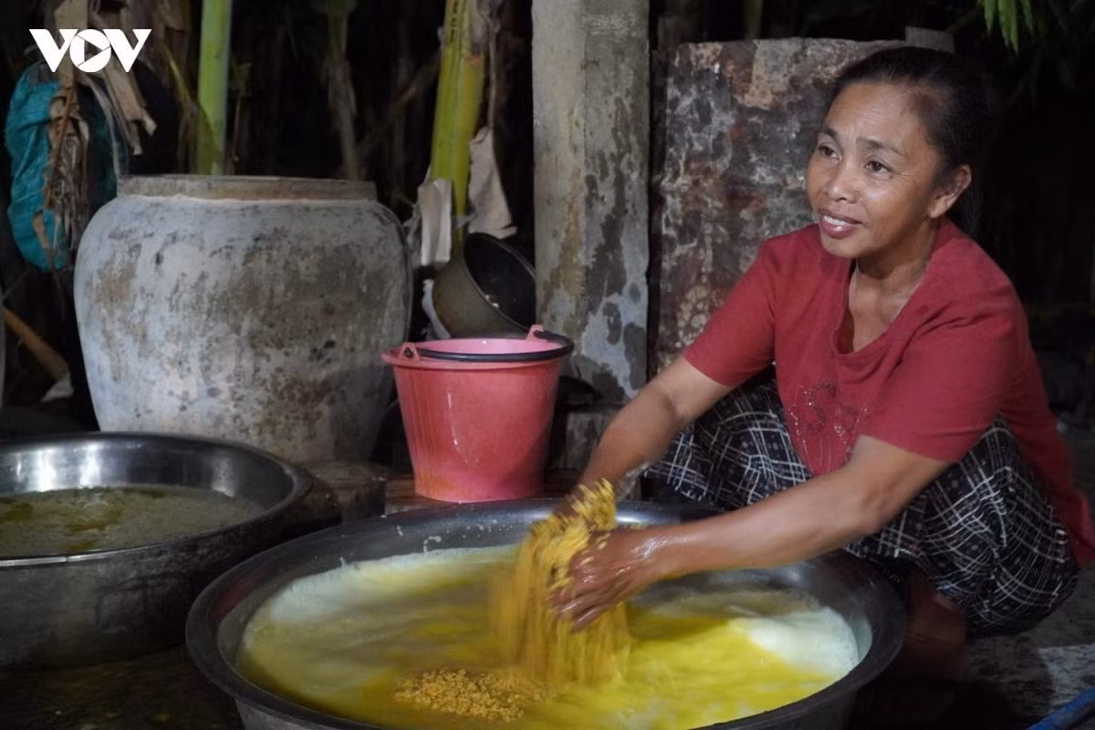 Mme Lê Thị Tịa, née d'un père laotien et d'une mère vietnamienne, a appris ce savoir-faire dès son plus jeune âge. Bien qu'installée à son compte depuis plus de 20 ans, elle reste passionnée par ce gâteau rustique.