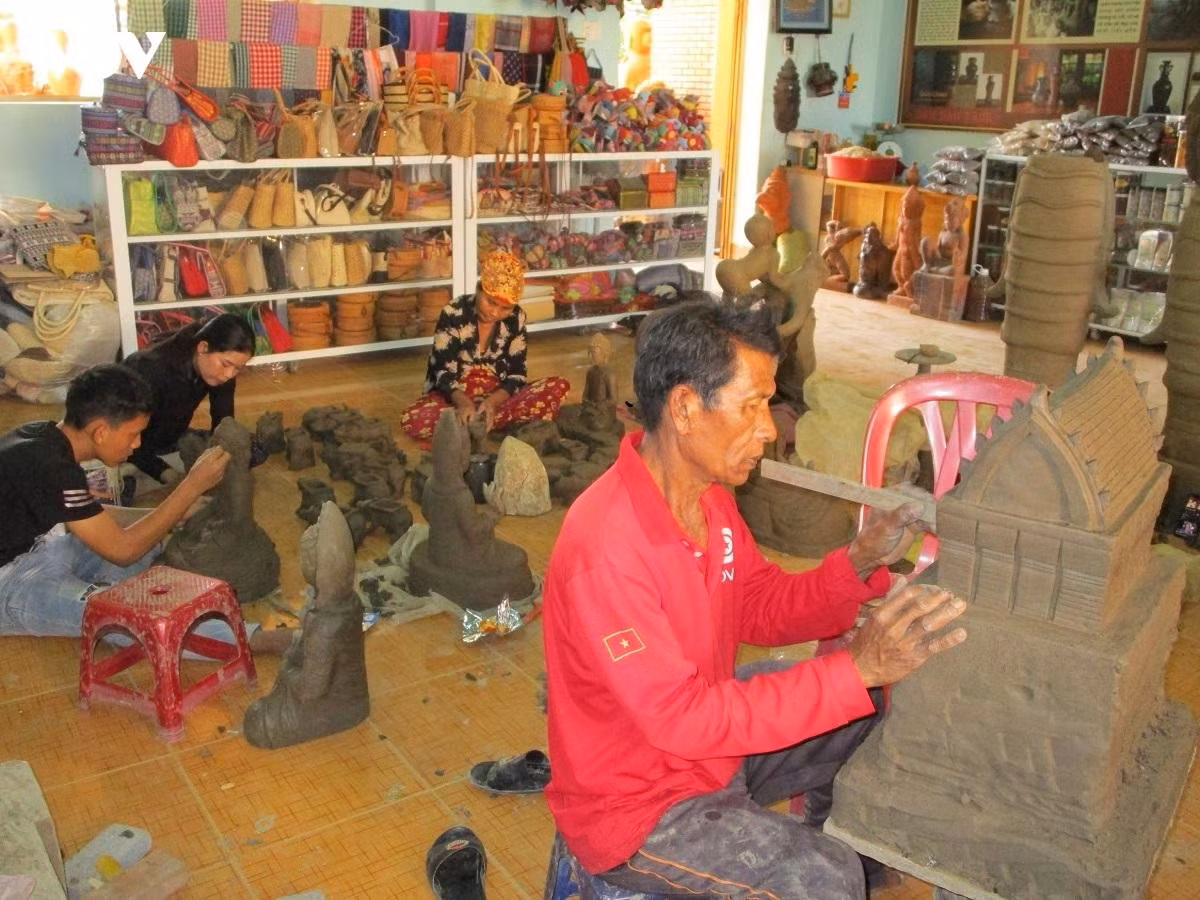 L’artisan (en rouge) façonne une tour cham en céramique.