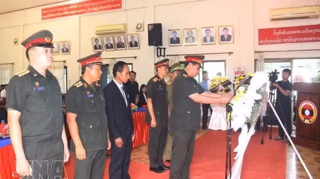 Des représentants des forces armées des provinces du sud du Laos ont déposé des fleurs lors de la cérémonie. Photo : VNA.