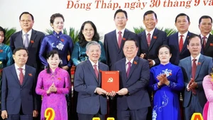 Nguyen Trong Nghia (troisième de droite à gauche), membre du Politburo, secrétaire du Comité central du Parti, chef de la Commission centrale de la sensibilisation et de l'éducation et et de mobilisation de masse du Parti, a présenté la décision au nouveau secrétaire du Comité provincial du Parti de Dong Thap, Ngo Chi Cuong. Photo : VNA.