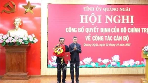 Le Minh Hung, membre du Bureau politique, secrétaire du Comité central du Parti et président de sa Commission d'organisation (droite) félicite Ho Van Nien. Photo ; VNA.