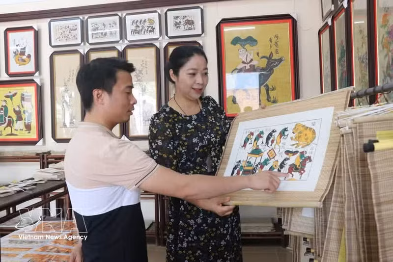 Des visiteurs admirent les estampes de Dong Ho. Photo: VNA