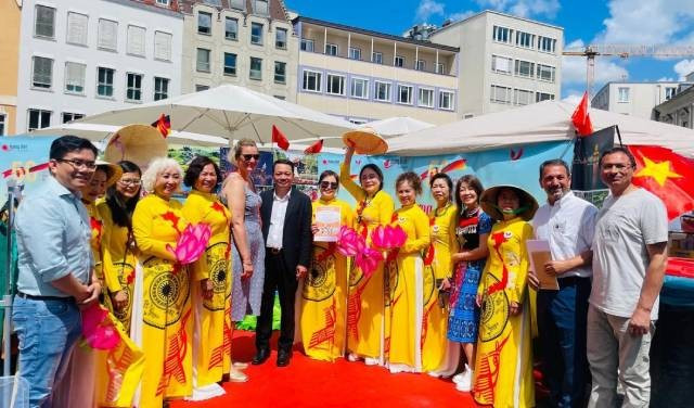 Des amis internationaux prennent une photo souvenir au stand du Vietnam. Photo : Revue Huong Viet.