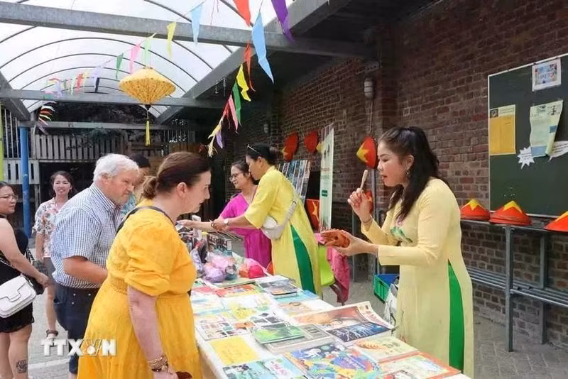 Des amis belges achètent des produits artisanaux pour collecter des fonds en faveur des enfants défavorisés au Vietnam. Photo : VNA. 