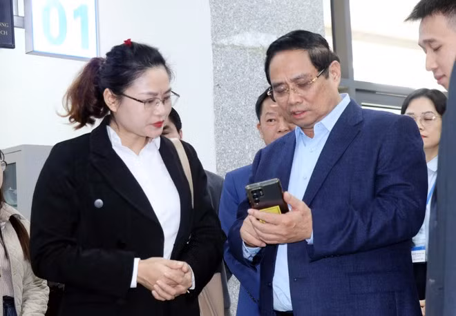 Le Premier ministre Pham Minh Chinh examine les évaluations des citoyens concernant la qualité des services publics. Photo : VNA