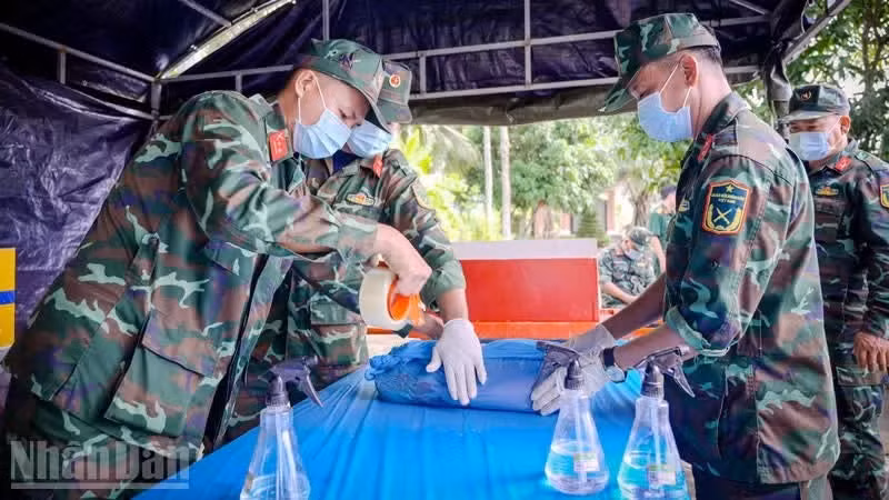 L’équipe de prélèvement recueille avec le plus grand soin des échantillons sur les dépouilles de martyrs non identifiés en vue de leur expertise génétique, au cimetière des martyrs de la province d’An Giang, dans le quartier de Rach Gia.