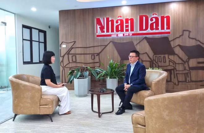 Le journaliste Lê Quôc Minh s'entretient avec le reporter du journal Tin Tuc &amp; Dan Toc. Photo : VNA.