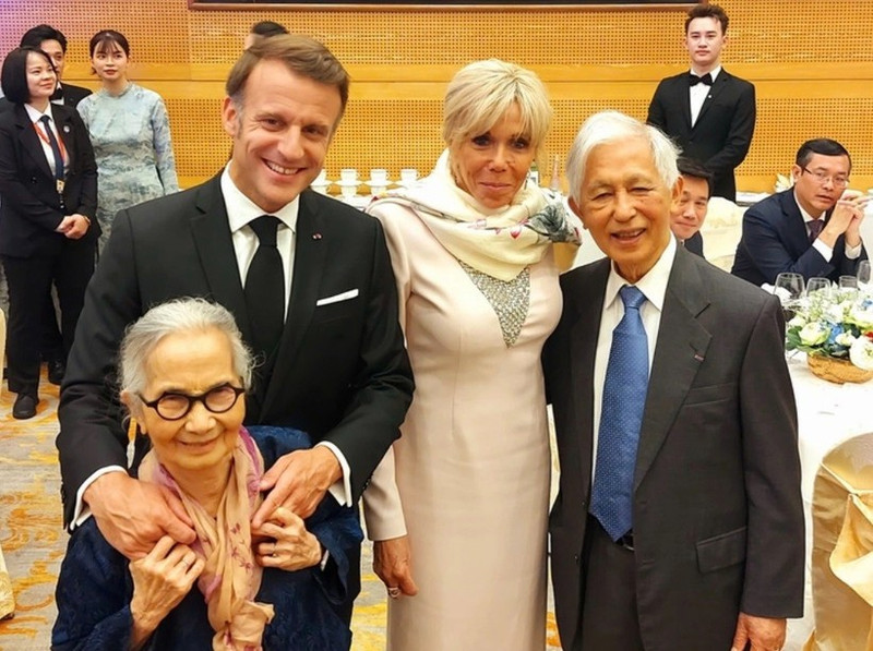 Le couple des professeurs Tran Thanh Van (à droite) et Le Kim Ngoc (à gauche) pose pour une photo avec le président de la République française et son épouse lors d’un dîner de réception à Hanoï, à l’occasion de la visite officielle du président en Vietnam. Photo : ICISE. 