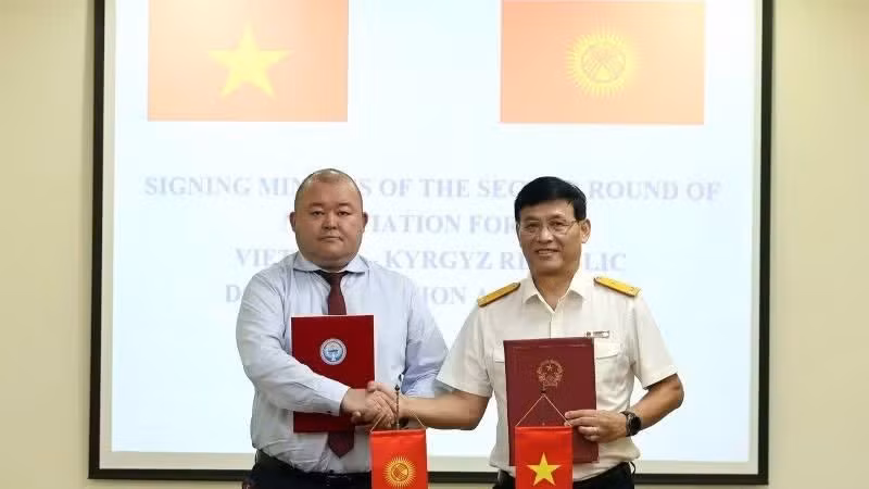 Le vice-directeur général Dang Ngoc Minh et M. Ruslan Tynaliev, chef du Département de la politique douanière du ministère de l’Économie et du Commerce du Kirghizstan, ont procédé à la signature. Photo : nhandan.vn