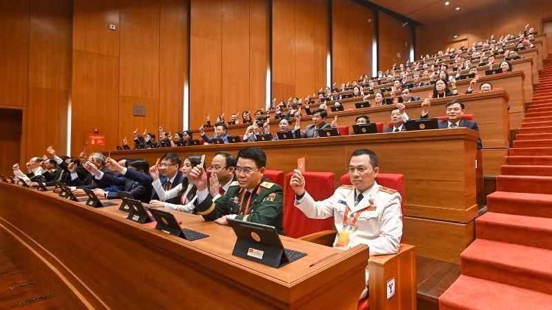 Les délégués votent l’adoption du règlement de fonctionnement du Congrès. Photo : nhandan.vn