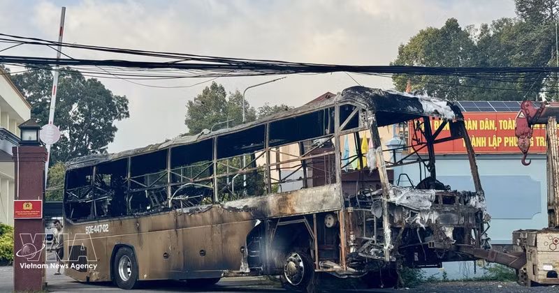 La carcasse calcinée de l'autocar est remorquée pour les besoins de l'enquête. Photo : VNA.
