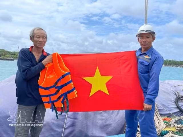 Remise d'un drapeau national à des pêcheurs. Photo : VNA. 