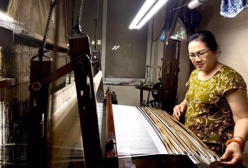 L'artisane Nguyen Thi Nhung devant son métier à tisser. Photo: VOV