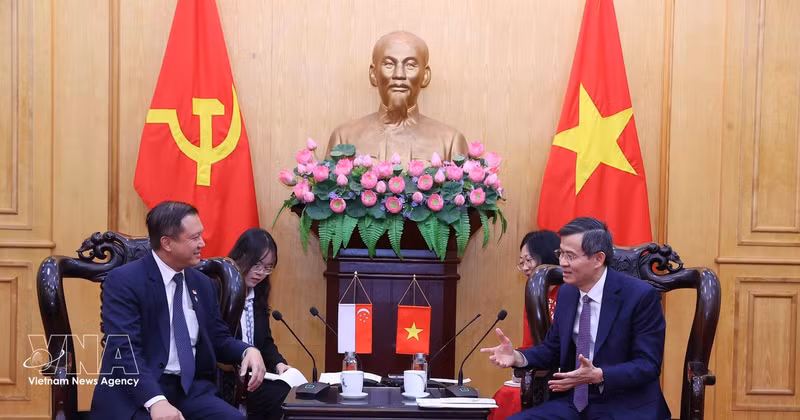 Doan Minh Huan (à droite), membre du Bureau politique et directeur de l’Académie politique nationale Hô Chi Minh, reçoit Lee Hong Chuang, député du PAP. Photo : VNA.