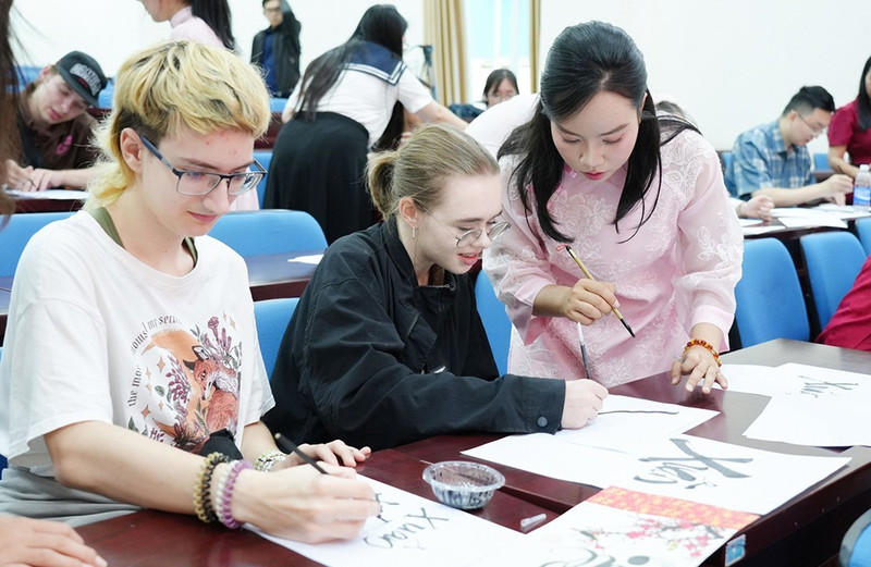 Des étudiants internationaux découvrent l’art de la calligraphie lors du programme « Têt vietnamien pour les étudiants internationaux » à l’Université pédagogique relevant de l'Université de Da Nang. Photo : Portail d’information électronique de la ville de Da Nang.