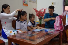 Des parents préparent les fournitures scolaires de leur enfant avant son départ pour l’école sur l’île de Trường Sa. Photo : baotintuc.vn