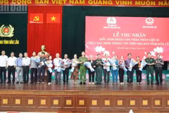 Le colonel Tran Binh Hung, directeur adjoint de la Police provinciale de Dak Lak, et des représentants des services et secteurs concernés remettent des cadeaux aux proches de martyrs lors de la cérémonie.