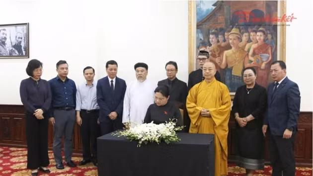 La vice-présidente et secrétaire générale du Comité central du FPV Ha Thi Nga écrit au registre de condoléance pour le président de l'Assemblée nationale lao, Xaysomphone Phomvihane. Photo : daidoanket.