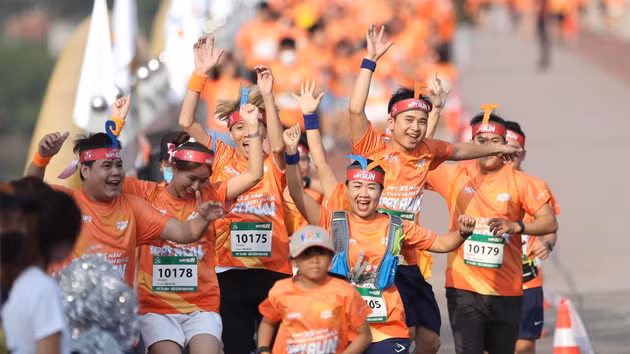 Les coureurs affichent leur enthousiasme lors de la course Happy Run, organisée pour soutenir la scolarisation des enfants issus de régions défavorisées. Photo : Vnexpress.