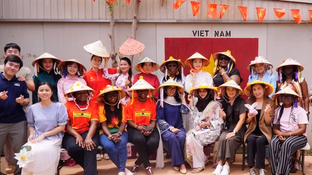 Des femmes militaires vietnamiennes et leurs homologues internationales participent à un atelier d’échange culturel consacré à la décoration de chapeau conique. Photo : QDND.