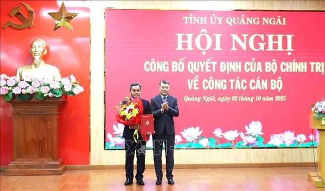 Le Minh Hung, membre du Bureau politique, secrétaire du Comité central du Parti et président de sa Commission d'organisation (droite) félicite Ho Van Nien. Photo ; VNA.