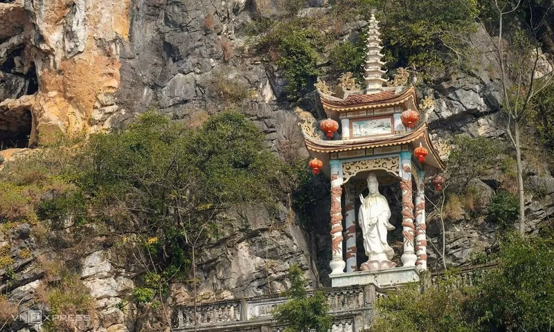 Sur le flanc de la montagne s'élève également une stūpa abritant une statue de bodhisattva. Se détachant sur le fond verdoyant des forêts et des reliefs rocheux, cet ouvrage constitue un lieu privilégié pour les fidèles venus offrir de l'encens et pour les visiteurs souhaitant admirer le paysage. Photo : Hoang Giang