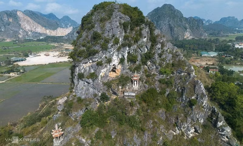 À l'arrière du sanctuaire principal, un sentier composé de plusieurs centaines de marches serpente sous une épaisse canopée avant de rejoindre les pentes du mont Hoang Nghieu. Depuis un promontoire situé à plus de 40 mètres d'altitude, les visiteurs bénéficient d'un vaste panorama sur les montagnes environnantes, les rizières et les villages de la campagne de Thanh Hoa. Photo : Hoang Giang