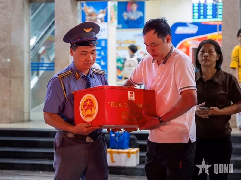 Des représentants de la société par actions des transports ferroviaires du Vietnam et de l'Association vietnamienne de soutien aux familles de soldats morts au combat remettent la dépouille du martyr Nguyen Van Yen à sa famille. Photo : qdnd.vn
