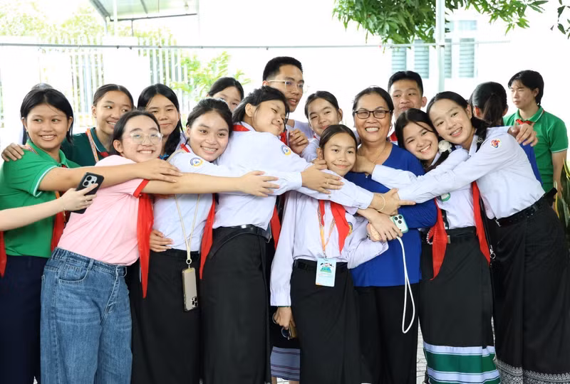 Les enfants ont exprimé toute leur affection envers les artisans qui les guident avec patience dans la préparation des galettes. Photo : tienphong.vn