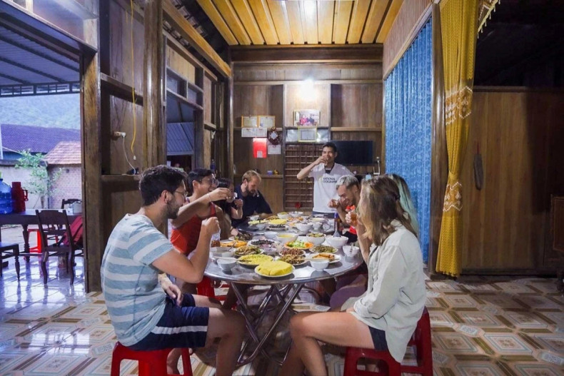 Des touristes internationaux dégustent un repas chez l'habitant à Tân Hoa. Photo : Oxalis Adventure.