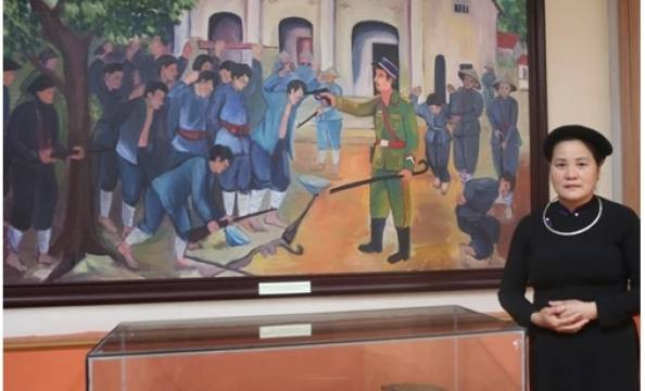 La guide Nông Thi Bich se tient à côté du tableau représentant la bataille de Phai Khat et des artefacts historiques de cette bataille. Photo : VOV. La guide Nông Thi Bich se tient à côté du tableau représentant la bataille de Phai Khat et des artefacts historiques de cette bataille. Photo : VOV.
