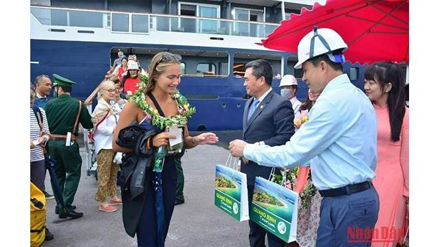 Des représentants du Service du tourisme de Quang Binh et du port Hon La accueillent et offrent des cadeaux aux touristes. Photo : NDEL. Des représentants du Service du tourisme de Quang Binh et du port Hon La accueillent et offrent des cadeaux aux touristes. Photo : NDEL.