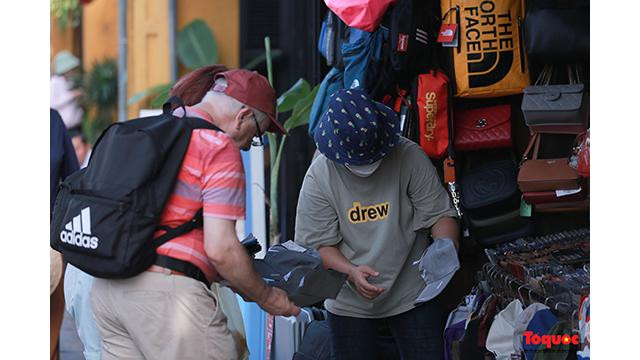 Certains visiteurs se rendent sur les étals pour acheter leurs cadeaux préférés... Photo: Journal Tô Quôc.